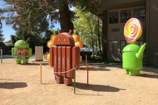 Statues of Android mascots themed after different versions: Android KitKat, Android Lollipop, and Android Jelly Bean are shown outside a building.