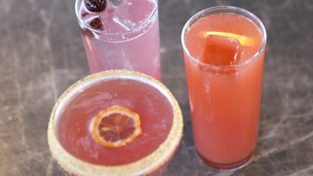 Three colorful cocktails: a pink drink, an orange drink, and a pink drink topped with a &ldquo;Touch Down&rdquo; flag.